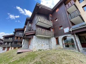 A multi-story building with balconies, stone facade, and a clear sky. - 2-Room Ski-In/Ski-Out Apartment with Balcony, Near Pierrafort Gondola (Les Avanchers-Valmorel)