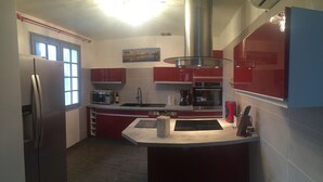 A modern kitchen with a stainless steel refrigerator, a microwave, and a coffee maker.