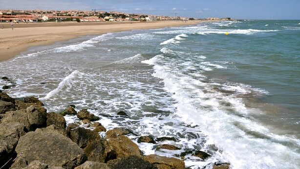 Une plage côtière avec un rivage rocheux et des vagues.
