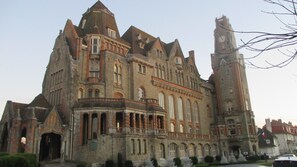 Ein großes, historisches Gebäude mit mehreren Türmen und einem markanten Glockenturm.