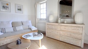 A modern living room with a sofa, a coffee table, a dresser, and a large mirror. - Magnificent Apartment in the heart of Uzès (Uzès)