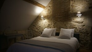 A bedroom with a stone wall, a sloped ceiling, and two wall-mounted lamps. - L 'Abeille bleue - Cottage *** - 4/6 people - Azay-le-Rideau - from 70 € / night (Cheillé)