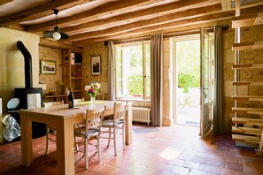 A rustic wooden interior with a dining table, chairs, a fireplace, and large windows. - L 'Abeille bleue - Cottage *** - 4/6 people - Azay-le-Rideau - from 70 € / night (Cheillé)