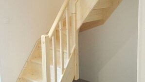 Una escalera de madera de diseño sencillo que conduce a una zona de descanso.