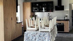 A modern kitchen with a dining area, wooden cabinets, and a built-in oven.