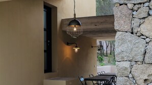 A stone wall, a staircase, and a table with chairs outside a building. - 4-person villa with private pool, close to the sea  (Pianottoli-Caldarello)