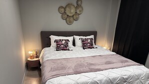 A neatly made bed with a white duvet and a pink throw blanket, a decorative wall piece above it, and a bedside table with a lamp. - The enchanted barn  (Profondeville)
