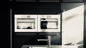 A modern kitchen with a stainless steel countertop and two built-in ovens. - The enchanted barn  (Profondeville)