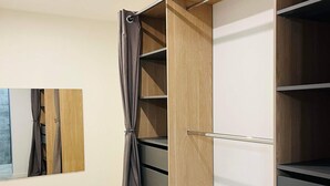 A walk-in closet with open shelves and a hanging rod. - House surrounded by olive trees, set against a hill, on 2000 m2 of quiet land (Ceyreste)