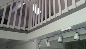 A white ceiling with a sloped design, a balcony with white railings, and a door with a wooden panel. - A stay by the lake ... (Génos)