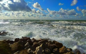 A rocky shoreline with waves crashing against the rocks. - Charming villa in STE-CECILE, sea {very close ) A 100M } (Camiers)