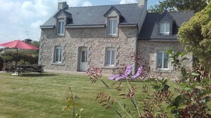 A stone house with a sloped roof, multiple windows, and a well-maintained lawn. - Brittany house south Finistère, in the countryside, quiet, independent, wifi (Bannalec)