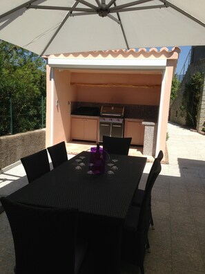 An outdoor patio with a table set for dining, a grill, and a covered seating area. - LUXURY VILLA WITH ALL COMFORTS, SWIMMING POOL. (Porto-Vecchio)