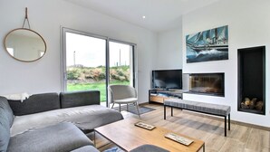 A modern living room with a sofa, coffee table, and a fireplace.