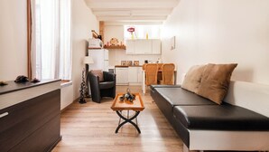 A modern living room with a sofa, a coffee table, and a dining area with a kitchen in the background. - House borders of Marne, between Disney and Paris! (Le Perreux-Sur-Marne)