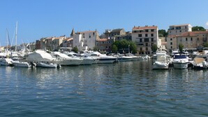 A marina with various boats docked, surrounded by buildings with traditional architecture.