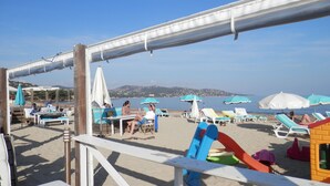 A beachside area with sun loungers, umbrellas, and a wooden deck. - Beau Mazet 75m2, large garden in pine forest, Private domain with Swimming pool, Tennis .. (Sainte-Maxime)