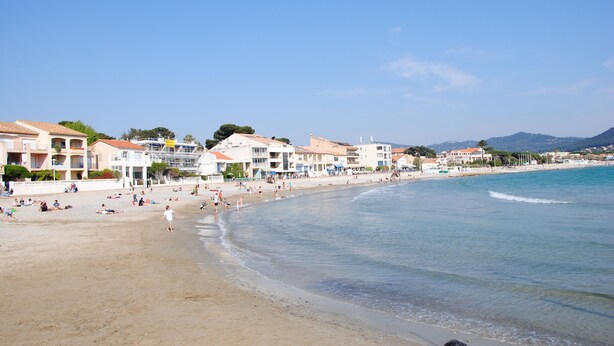 A beach with buildings along the shore, clear skies, and people enjoying the beach. - T2 apartment, 40 m2 350m from Lecques beach, quiet. Air conditioning. Private parking (Saint Cyr sur Mer)