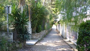 A gravel pathway flanked by greenery and a white fence. - T2 apartment, 40 m2 350m from Lecques beach, quiet. Air conditioning. Private parking (Saint Cyr sur Mer)
