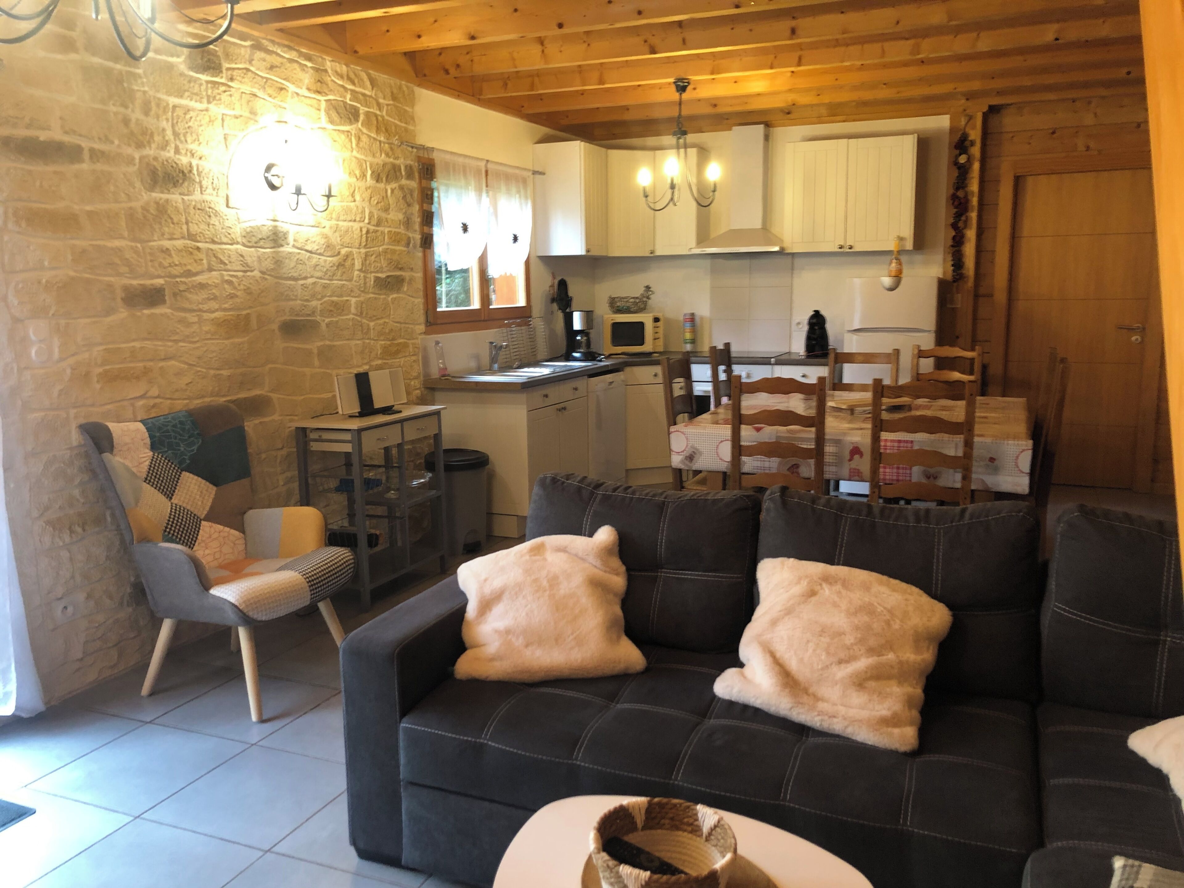 Una sala acogedora con un sofá, una mesa de comedor y una cocina al fondo.