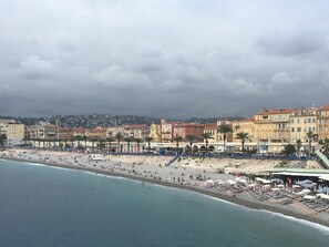 Paisagem costeira com uma praia, edifícios e céu nublado.