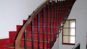 A staircase with red steps and black balusters.