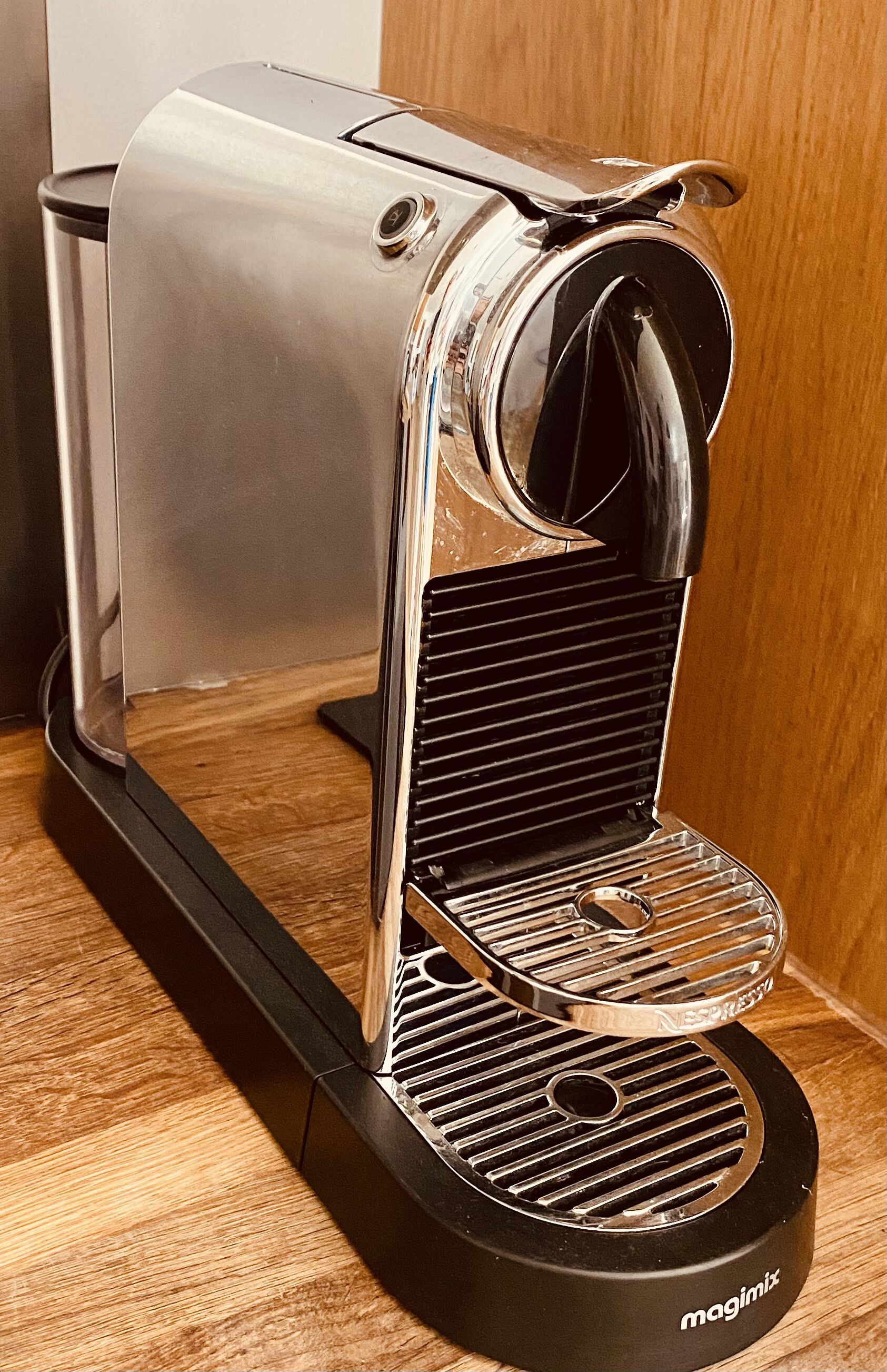 En kompakt, moderne espressomaskine med et strømlinet design, digitalt display og en gennemsigtig vandbeholder.