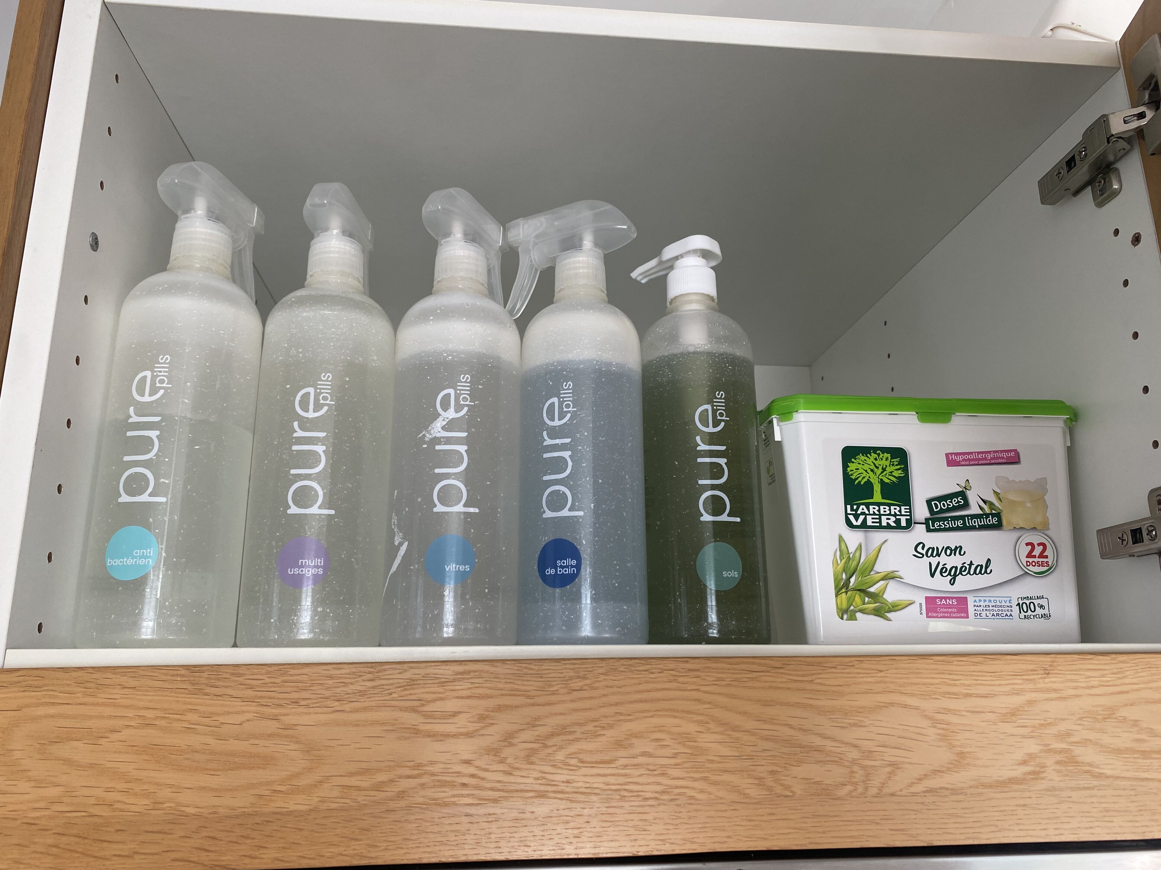A shelf with various bottles of 'pure pills' and a container of 'Savon Végétal'.
