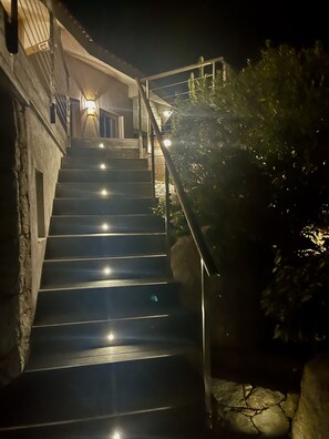 Stairs lead to an upper level with a balcony and door.