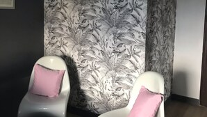 A room with two white chairs with pink cushions, a small round table, and a patterned wallpaper. - *** house in Mont Saint Michel bay for 2 to 5 people (Saint-Broladre)