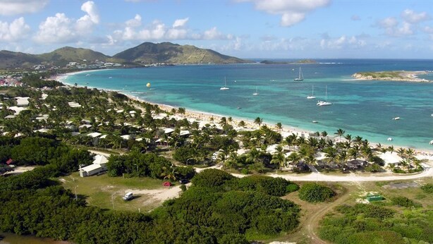 A coastal resort with beach access, clear turquoise waters, and lush greenery. - BEAUTIFUL STUDIO NEAR THE BEACH IN THE HEART OF THE ORIENT BAY VILLAGE (Orient Baie)