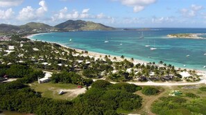 A coastal resort with a beach, clear turquoise waters, and boats.