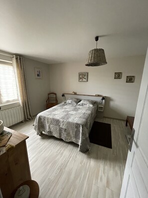 A bedroom with a bed, a bedside table, a lamp, and a window with curtains. - Quiet, dead-end street, 10 minutes' walk from the town center, ground floor (Sarlat-La-Canéda)