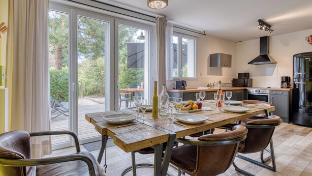 Una cocina moderna con comedor, ventanas amplias y vistas al exterior.