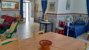 A cozy living room with a sofa, chairs, a dining table, and a bed. - typical house in Spain in ALMERIA, Andalusia 6 people quiet (almeria)
