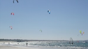 A beach with multiple kites flying in the sky. - The terraces of the bay 'between land and sea' (Plounévez-Lochrist)