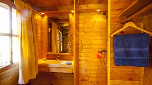 Ein Badezimmer in einer Holzhütte mit Waschbecken, Spiegel und Handtuchhalter.