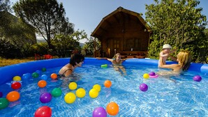 Ein aufblasbarer Pool mit Personen und bunten Bällen.