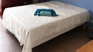 Un dormitorio con cama, armario, un cuadro y lámpara.