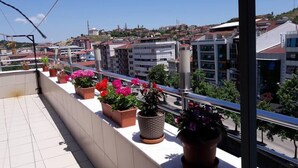 Un balcón con plantas en macetas y vistas a la ciudad.