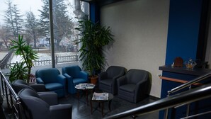 Un vestíbulo con asientos, una mesa de centro y un ventanal con vistas al exterior.