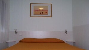 A room with a bed, two bedside tables, and a framed picture on the wall. - Vacation Rental in Cambo-Les-Bains: 2-room, air-conditioned, fully equipped—panoramic view. (Cambo-Les-Bains)