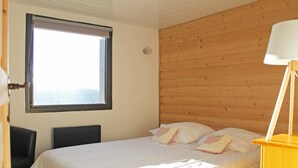 Een slaapkamer met een bed, een raam en een lamp.