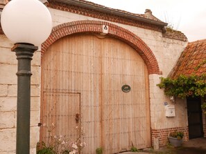 Una puerta de madera grande con un arco de ladrillo, una farola y un pequeño letrero con el logotipo de un canguro.