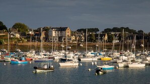 Uma marina com vários barcos atracados, rodeada por edifícios e árvores.