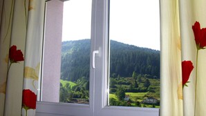 A window with a view of a green landscape and hills. - Renovated stone house, classified 3 stars between La Bresse and Gérardmer (Basse-Sur-Le-Rupt)