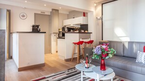 Un apartament modern amb cuina, menjador i sala d'estar.