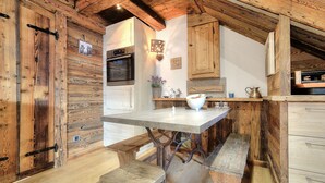 Une cuisine rustique avec des murs en bois, un îlot central et un four encastré.