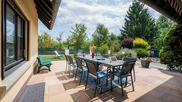 An outdoor patio with a table and chairs, a bench, and potted plants. - Large and beautiful detached house in a quiet and relaxing setting (Ruederbach)