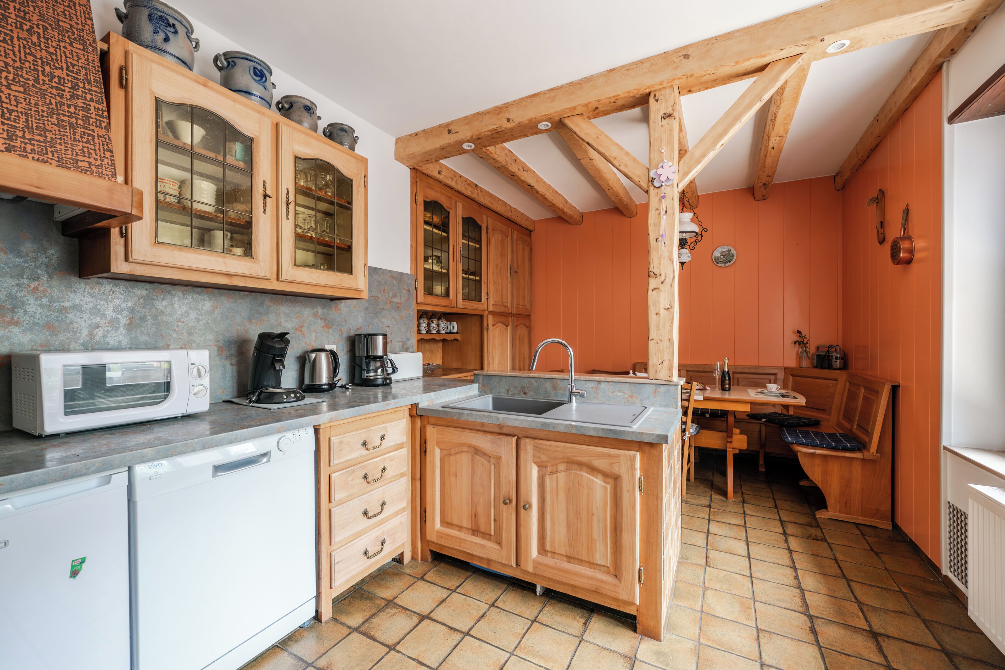 A compact kitchen with wooden cabinets, a built-in microwave, and a sink.